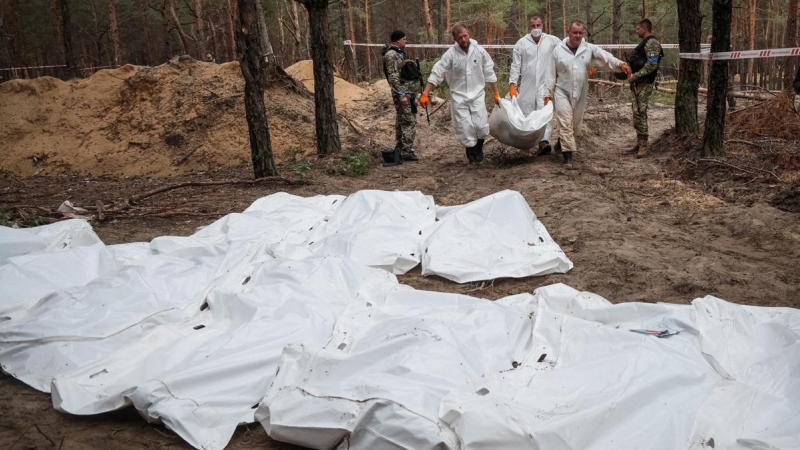 Técnicos mueven los cuerpos hallados en una fosa común en la ciudad de Izium, a 16 de septiembre de 2022.