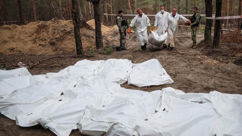 Técnicos mueven los cuerpos hallados en una fosa común en la ciudad de Izium, a 16 de septiembre de 2022.