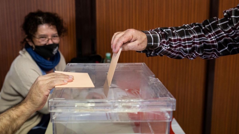 Imagen de archivo de una persona introduciendo su voto en una urna, a 23 de octubre de 2021, en Madrid.