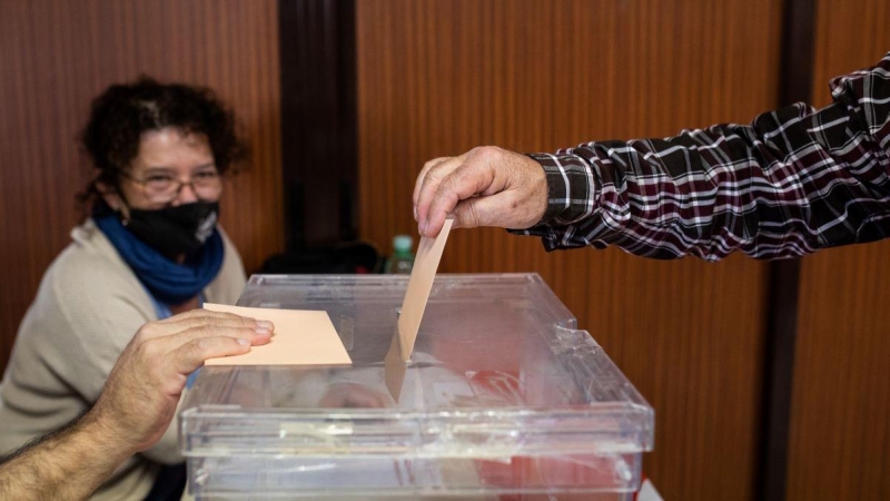 Imagen de archivo de una persona introduciendo su voto en una urna, a 23 de octubre de 2021, en Madrid.