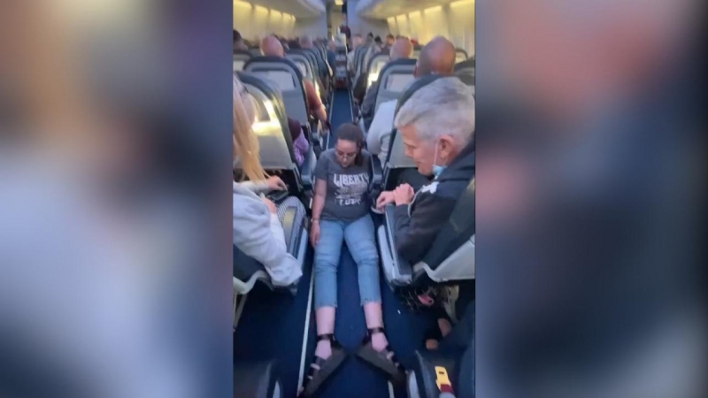 Una mujer se arrastra por el suelo de un avión