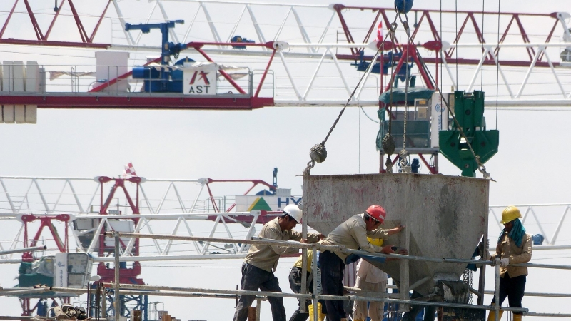 Fotografía de obreros sobre una construcción en horas de trabajo.