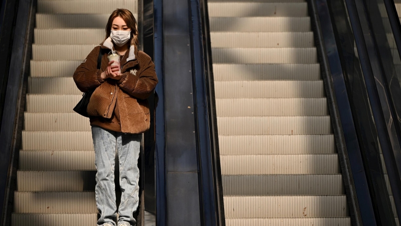 Una mujer con mascarilla en una estación de Melbourne.