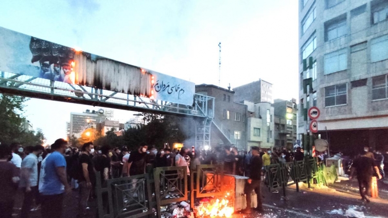 La gente se enfrenta a la policía durante una protesta tras la muerte de Mahsa Amini, en Teherán, Irán.