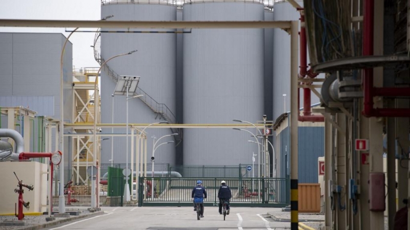 Dos trabajadores montan en bicicleta en la planta de regasificación de Enagas en Barcelona, ​​la más antigua de Europa continental.