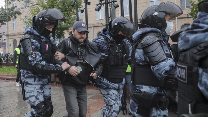 Policías rusos detienen a una persona que participaba en una protesta no autorizada contra la movilización militar parcial de Rusia por el conflicto en Ucrania.