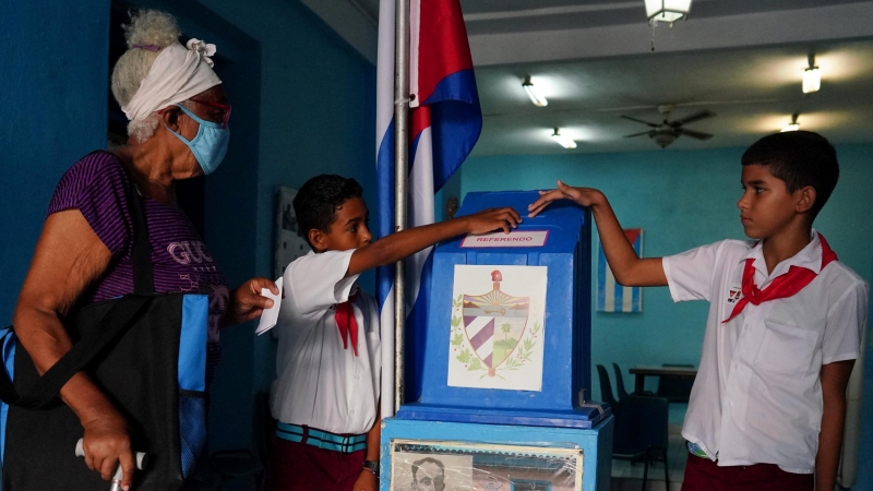Los niños ayudan a una votante a emitir su voto en un colegio electoral durante el referéndum del nuevo Código de Familia en La Habana, Cuba , el 25 de septiembre de 2022.