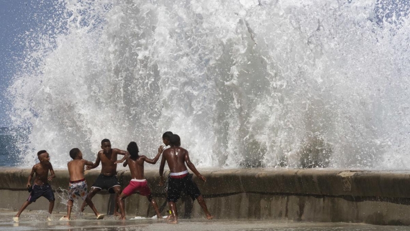 Varios jóvenes se divierten con las fuertes olas, en La Habana, Cuba, a 29 de septiembre de 2022.