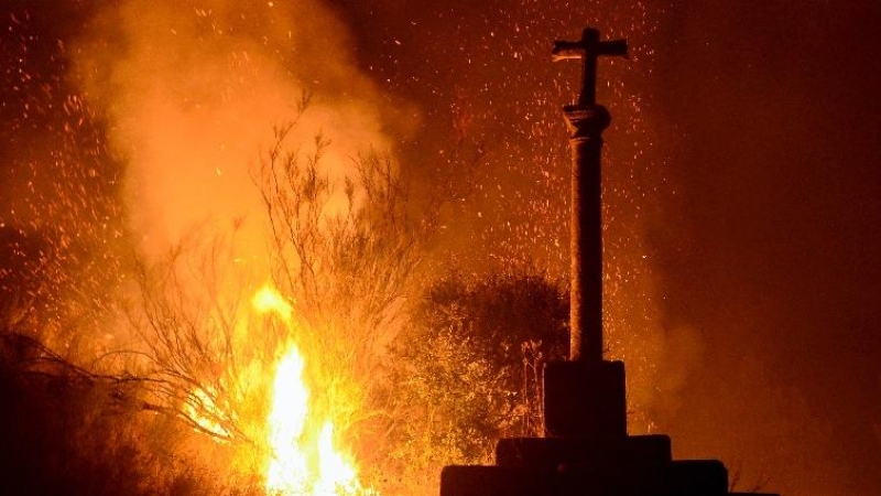 3/10/22 Un cruceiro rodeado por las llamas en un incendio forestal en la comarca de Valdeorras.