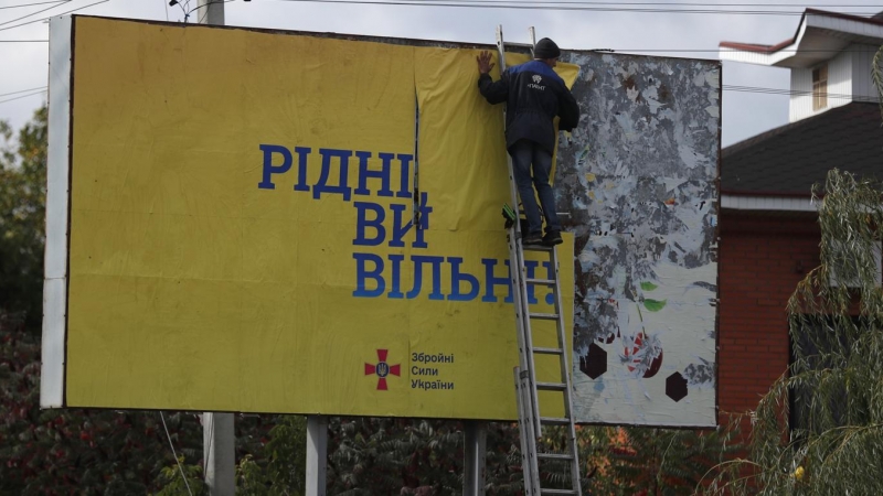 Un hombre colocauUn cartel que dice 'Ciudadanos, sois libres' en la ciudad recién liberada de Kupiansk, al este de Kharkiv, Ucrania, este lunes 3 de octubre de 2022.