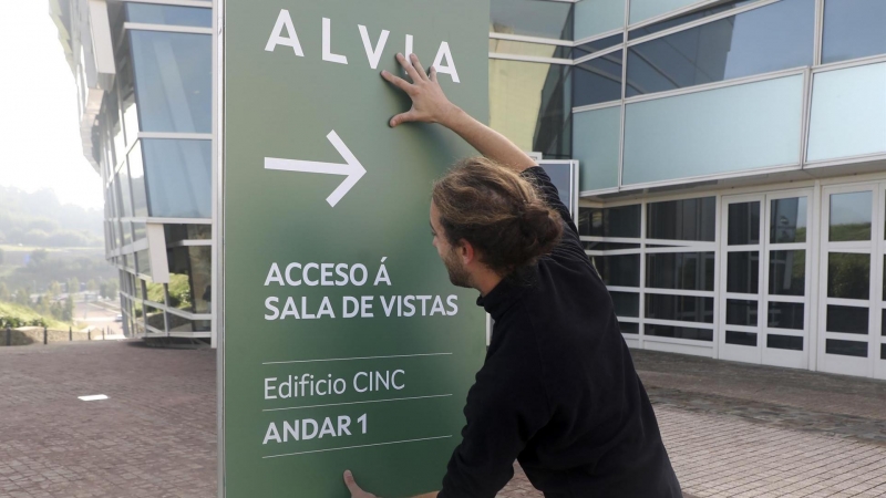 04/10/2022-Un hombre coloca un cartel informativo en la Ciudad de la Cultura que acogerá el juicio por el accidente del Alvia el 4 de octubre de 2022.