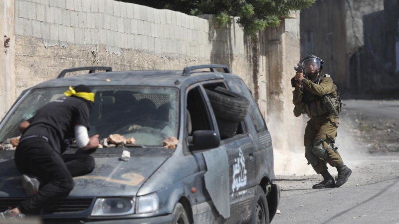 Un soldado israelí apunta su arma durante enfrentamientos con manifestantes palestinos.