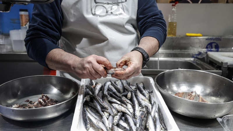 Un vendedor limpia pescado en un puesto de pescado en el Mercado Central de Valencia, a 24 de marzo de 2022, en Valencia, Comunidad Valenciana, (España).