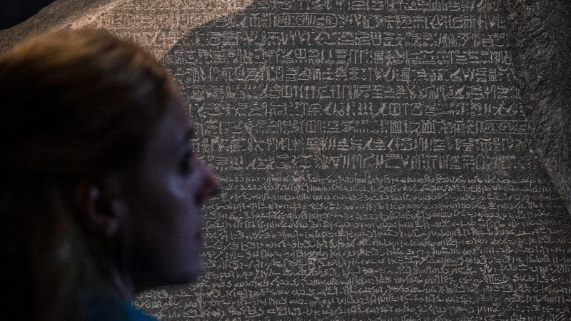 11/10/2022-Un miembro del personal observa la Piedra Rosetta expuesta en la exposición 'Jeroglíficos: descubriendo el antiguo Egipto' en el Museo Británico, en Londres, el 11 de octubre de 2022.
