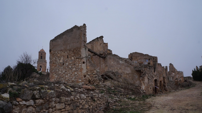 Calle de un pueblo destruido en Corbera de Ebro, y al fondo, el campanario de la Iglesia de San Pedro, bombardeada durante la Guerra Civil.