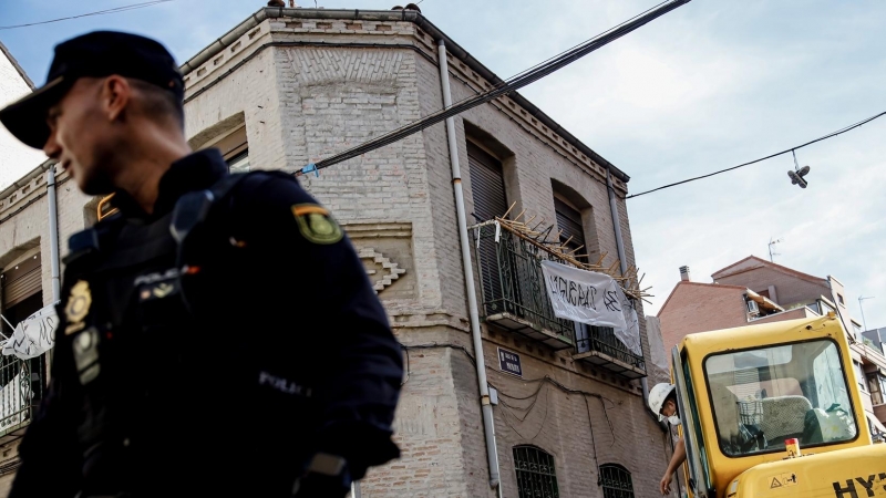 Un agente de Policía Nacional frente a una máquina retroexcavadora durante la demolición del edificio okupado ‘La Higuera’, en el barrio de Tetuán, a 14 de octubre de 2022, en Madrid (España).