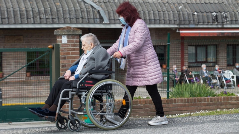 17/04/2021-Una mujer pasea a una anciana en silla de ruedas, en las inmediaciones de la residencia geriátrica de As Gándaras para visitar a un familiar, a 17 de abril de 2021, en Lugo, Galicia (España)