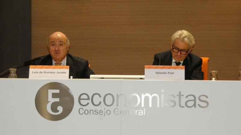 El vicepresidente del BCE, Luis de Guindos (i), junto al presidente del Consejo General de Economistas de España (CGE), Valentín Pich (d), durante un evento informativo de los economistas, en Madrid.  EFE