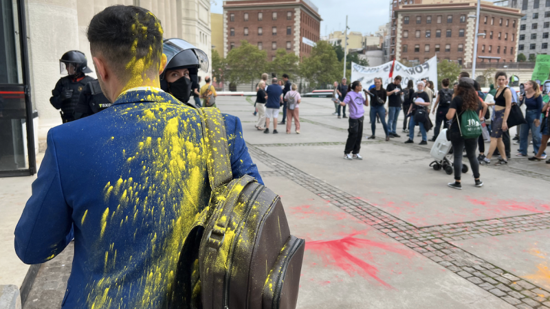 Un congressista tacat de pintura quan entrava a The District, amb manifestants al fons