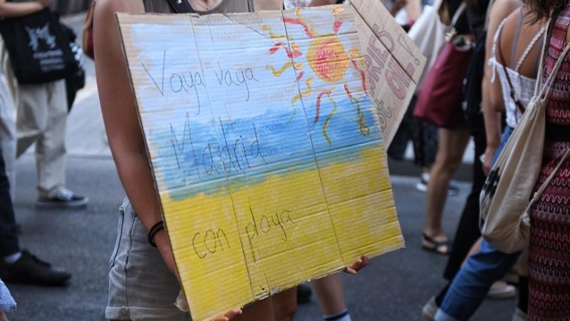 Una joven sostiene una pancarta en una manifestación por el clima para exigir un cambio en el sistema energético, en la Plaza Mayor, en Madrid (España).
