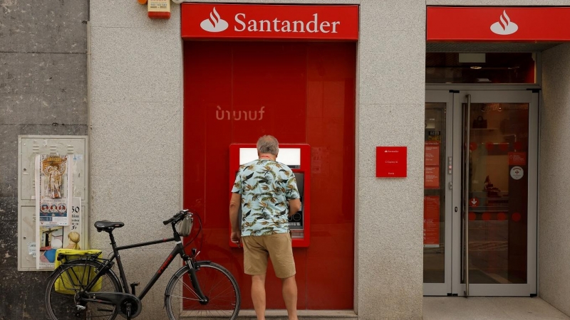 Un hombre utiliza el cajero automático de una oficina del Banco Santander en Ronda (Málaga). REUTERS/Jon Nazca