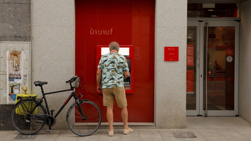 Un hombre utiliza el cajero automático de una oficina del Banco Santander en Ronda (Málaga). REUTERS/Jon Nazca
