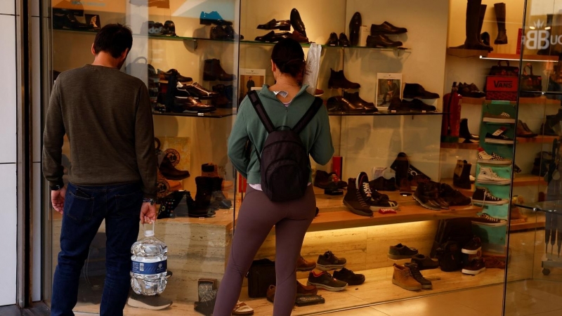 Una pareja frente a un escaparate de una tienda de calzado en la localidad malagueña de Ronda. REUTERS/Jon Nazca