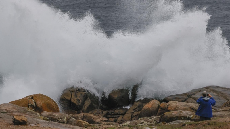 Un turista fotografía las olas en Muxía (A Coruña).