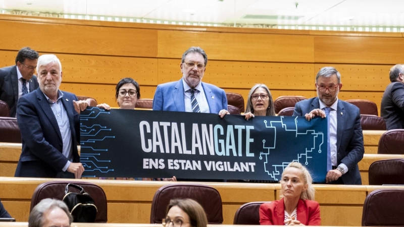 Los senadores de Junts per Catalunya (JxCat) con un cartel en el que se lee: 'Catalangate ens estan vigilant'. Imagen de Archivo.