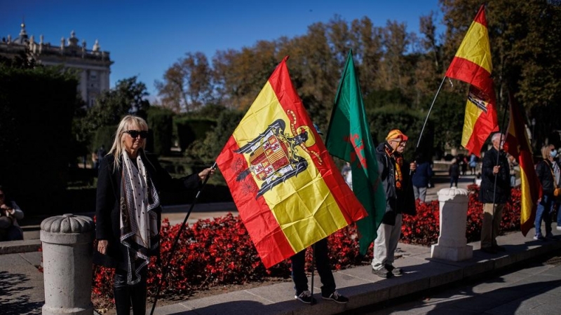 Varias personas, con banderas de España con el águila de San Juan, asisten a un acto organizado por el Movimiento Católico español (MCE) en memoria de Francisco Franco y José Antonio Primo de Rivera, en la Plaza de Oriente, a 20 de noviembre de 2022, en M