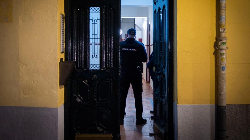 Un agente de Policía en el portal del edificio donde han hallado muerta a un joven de 20 años, a 28 de noviembre de 2022.