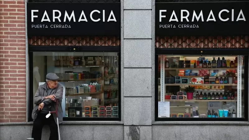 Un hombre mayor sentado en el escaparate de una farmacia en Madrid. REUTERS/Juan Medina