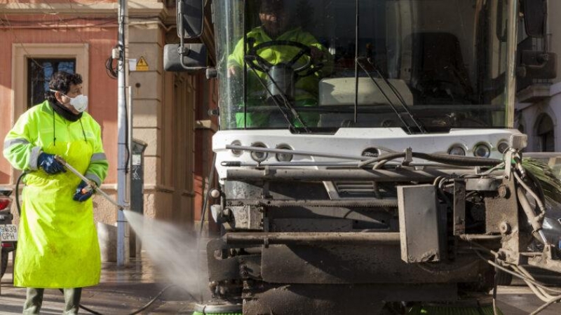 Un trabajador de la limpieza utiliza agua a presión para limpiar las aceras.