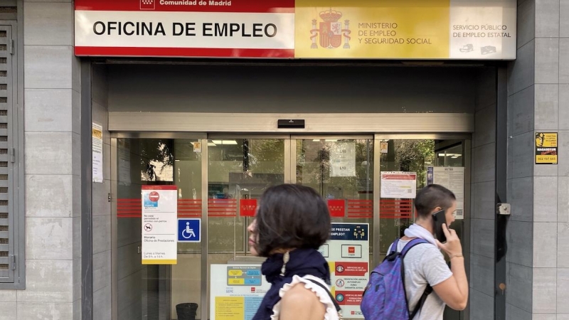 Dos personas pasan por la oficina de empleo de Acacias, a 4 de octubre de 2022, en Madrid.
