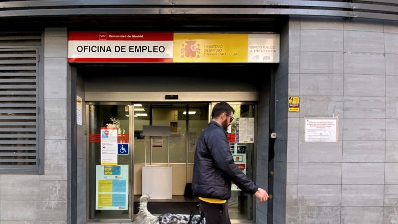 Un hombre pasa con su perro por la oficina de empleo de Acacias, a 4 de octubre de 2022, en Madrid (España).