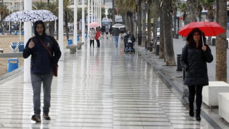 Turistas bajo la lluvia, el pasado viernes, en el paseo de Benidorm