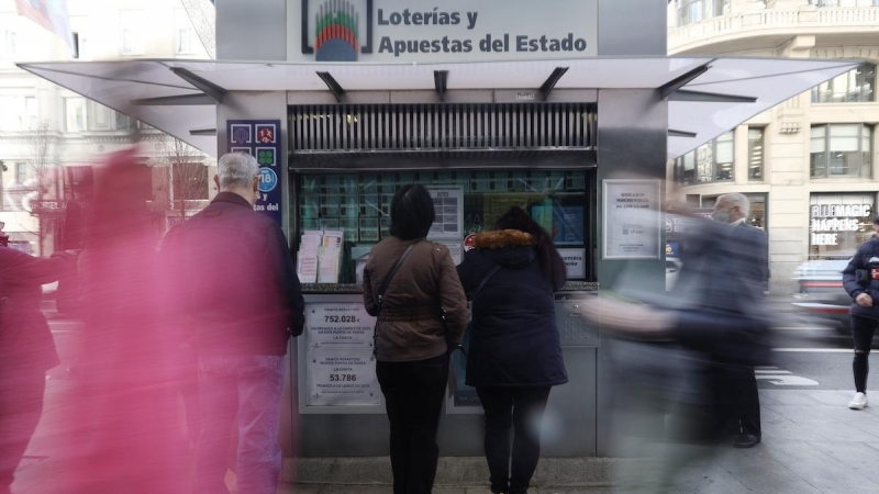 Varias personas en las inmediaciones de una administración de loterías, tres días antes del Sorteo de La Lotería del Niño, a 3 de enero de 2022, en Madrid.