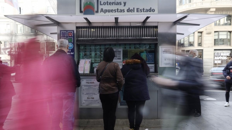 Varias personas en las inmediaciones de una administración de loterías, tres días antes del Sorteo de La Lotería del Niño, a 3 de enero de 2022, en Madrid.