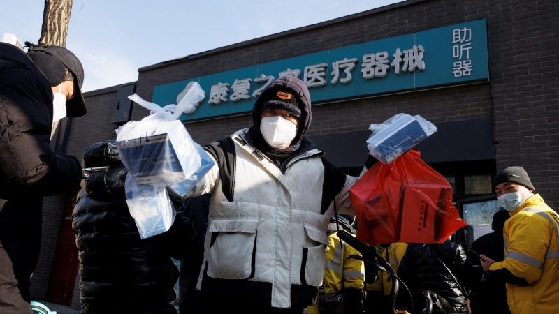 Un repartidor recoge medicamentos de una farmacia mientras continúan los brotes de la enfermedad por coronavirus (covid-19) en Pekín, el 7 de diciembre de 2022