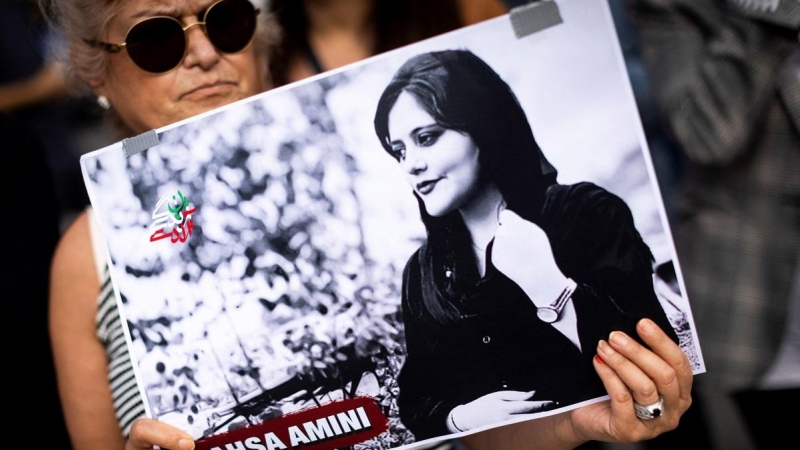 Una manifestante sostiene en París una pancarta con un retrato de Mahsa Amini, cuya muerte fue el detonante de las protestas en Irán