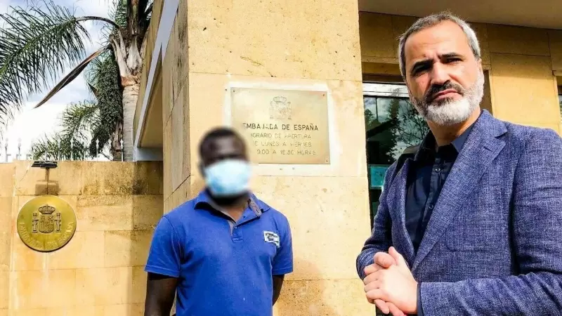 El joven sudanés Basir (nombre ficticio para proteger su identidad) junto a su abogado Arsenio G. Cores en la Embajada de España en Marruecos, a 13 de diciembre de 2022.