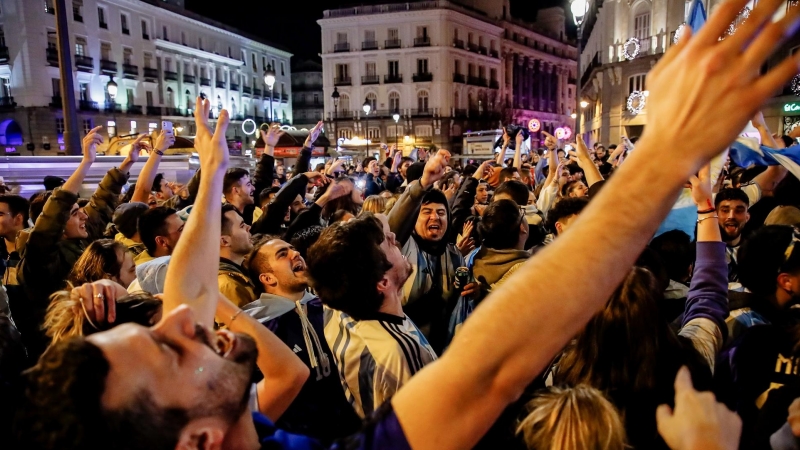 Cientos de aficionados argentinos celebran la victoria de la Selección Argentina en el Mundial de Catar 2022 en la Puerta del Sol de Madrid.