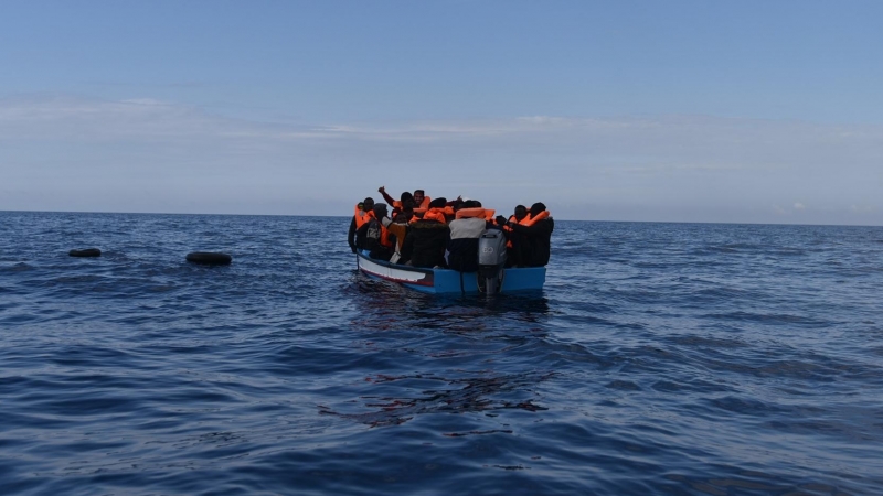 Imagen de archivo de varias personas migrantes en un bote de madera, antes de ser rescatadas por la ONG Open Arms.