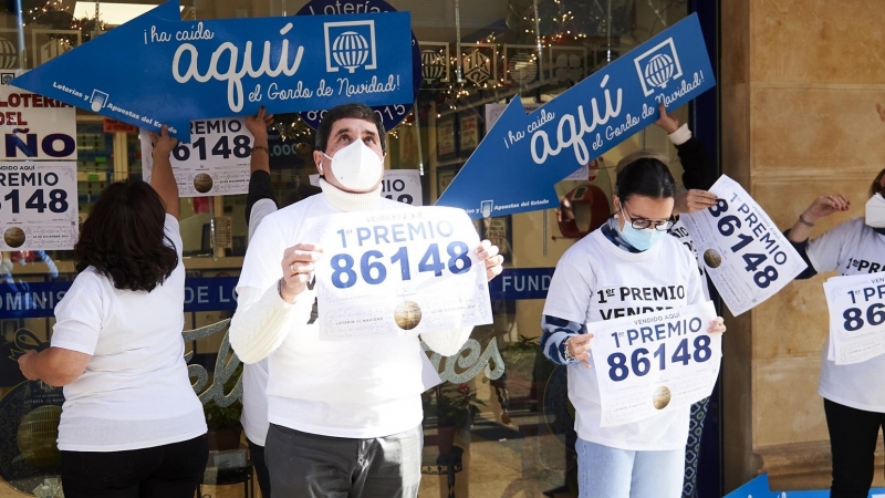 Empleados de la administración situada en la calle Cervantes de Santoña celebran que han vendido parte del número 86148 correspondiente al 'Gordo' del Sorteo Extraordinario de la Lotería de Navidad, a 22 de diciembre de 2021