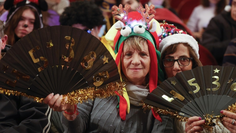 Varias personas disfrazadas esperan el comienzo del sorteo de El Gordo de Navidad en el Teatro Real en Madrid, este jueves.
