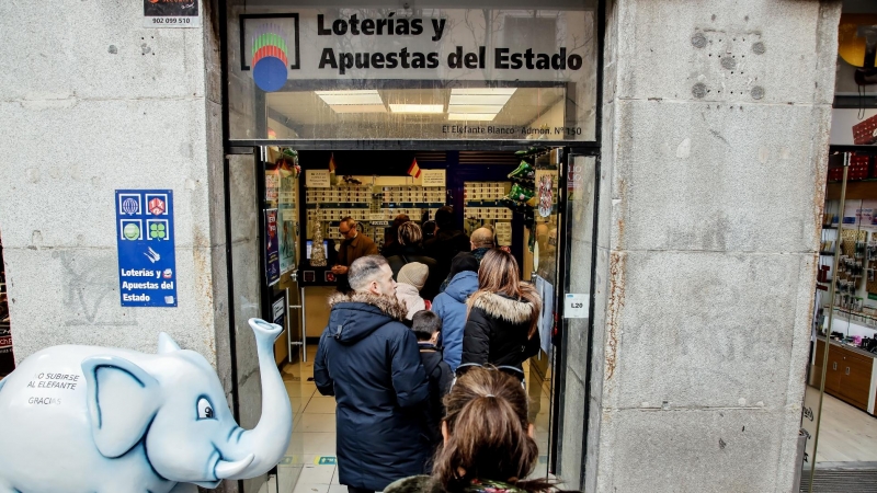 Varias personas hacen cola para comprar lotería para el Sorteo Extraordinario del Niño, a 2 de enero de 2023, en Madrid