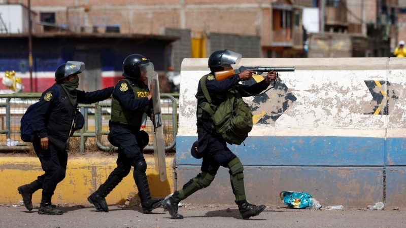 Oficiales de policía peruanos operan mientras los manifestantes realizan una protesta exigiendo elecciones anticipadas y la liberación del líder peruano Pedro Castillo