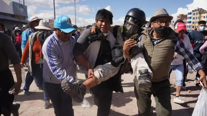Varios hombres ayudan al fotógrafo de la Agencia EFE Aldair Mejía, herido en una pierna mientras hacía el cubrimiento fotográfico de los enfrentamientos entre grupos de manifestantes y la Policía, en Juliaca (Peru).