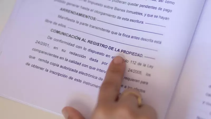 Una mujer señala una escritura de compraventa de una hipoteca, a 30 de mayo de 2022