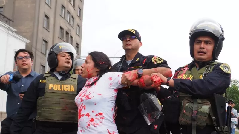 Policías antidisturbios arrestan a una mujer luego de arrojar pintura roja a policías cuando cientos marchan por la paz en Lima y las principales ciudades del país luego de los disturbios de diciembre pasado contra el actual gobierno de Dina Boluarte y el